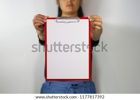 Woman holding red folder with paper