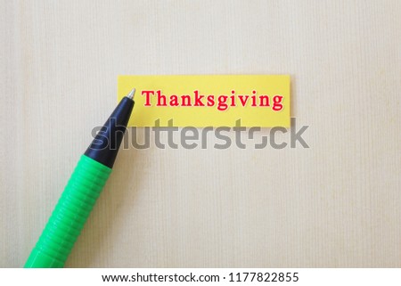 Green pen placed on the yellow paper and have thanksgiving text for the design in you festival concept.