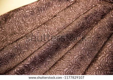 Brown fabric for dress, With patterns In the form of roses, fabric background, folds of fabric