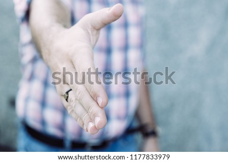 Man reaching for handshake outdoors. Close-up of male hand with ring. Entrepreneur greeting partner. Welcoming concept with gesture