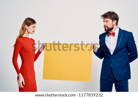 man with a woman holding a yellow layout                           