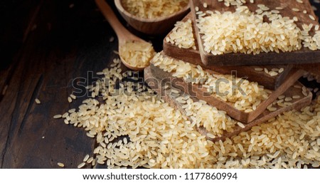 Parboiled rice with a wooden spoon close up