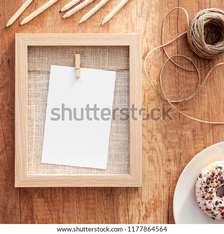 Autumnal mockup with wooden frame, colorful sprinkle donut, natural string and crayons