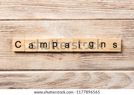 campaign word written on wood block. campaign text on table, concept.