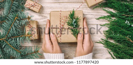 Woman wrapping modern Christmas gifts presents at home.