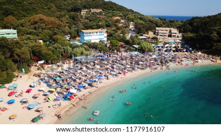 Aerial drone bird's eye view of popular beach of Sarakiniko with beautiful emerald sandy beach full of sunbeds at summer time, Epirus, Ionian, Greece