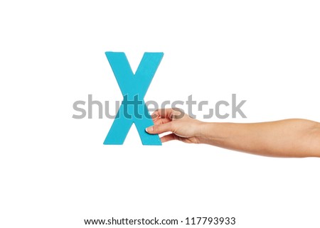 Female hand holding up the uppercase capital letter X isolated against a white background conceptual of the alphabet, writing, literature and typeface