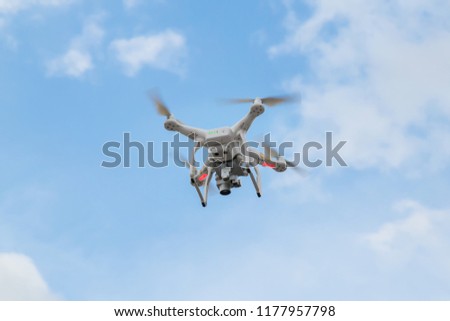 Drone copter flying with digital camera.Drone with high resolution digital camera. Flying camera take a photo and video.The drone with professional camera takes pictures of the blue sky.