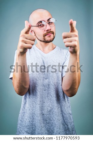A man in glasses with emotions and gestures on a gray background