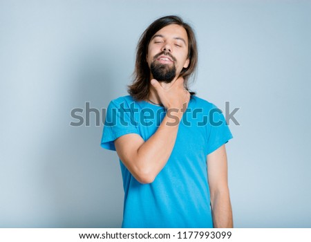 a handsome man has a sore neck, an isolated studio photo on the background