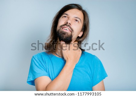a handsome man has a sore neck, an isolated studio photo on the background