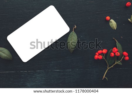 Flat lay business card with rounded corners mock up copy space top view on dark background decorated with wild berry fruit arrangement