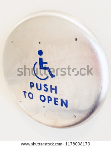 Push to open button for wheelchair accessibility