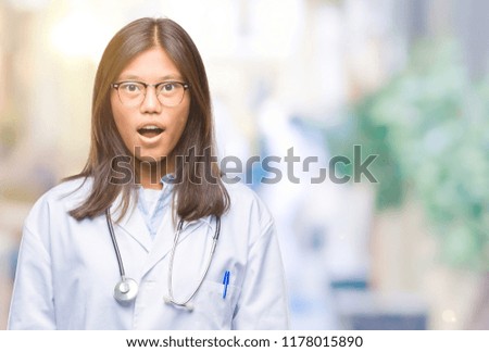 Young asian doctor woman over isolated background afraid and shocked with surprise expression, fear and excited face.