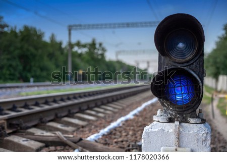 Traffic light shows blue signal on railway. Green light