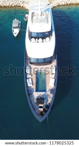 Aerial drone bird's eye view photo of luxury yacht with wooden deck and pool docked in ocean deep blue waters
