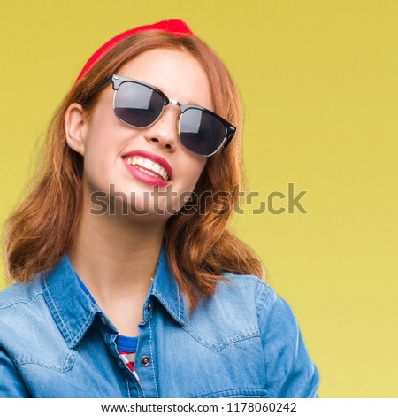 Young beautiful woman over isolated background wearing sunglasses happy face smiling with crossed arms looking at the camera. Positive person.