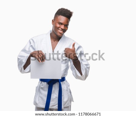 Young african american man over isolated background wearing kimono holding paper happy with big smile doing ok sign, thumb up with fingers, excellent sign