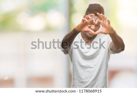 Young african american man over isolated background smiling in love showing heart symbol and shape with hands. Romantic concept.