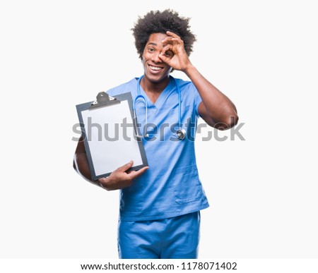 Afro american surgeon doctor holding clipboard man over isolated background with happy face smiling doing ok sign with hand on eye looking through fingers
