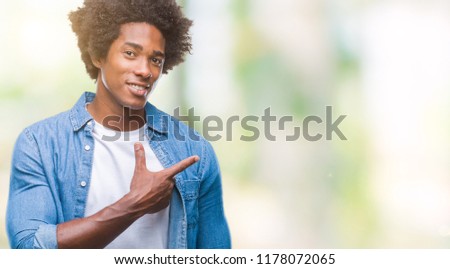 Afro american man over isolated background cheerful with a smile of face pointing with hand and finger up to the side with happy and natural expression on face looking at the camera.