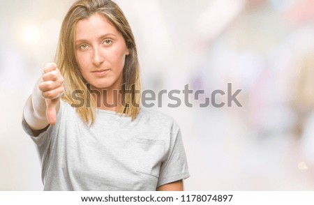 Young beautiful woman over isolated background looking unhappy and angry showing rejection and negative with thumbs down gesture. Bad expression.