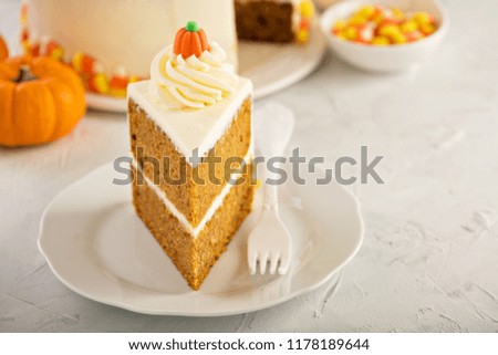 Pumpkin layered cake with cream cheese frosting decorated with candy