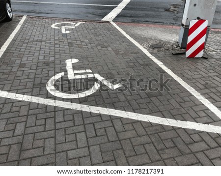 Parking place sign for disabled on grey dark brick. Marked parking for people with special needs
