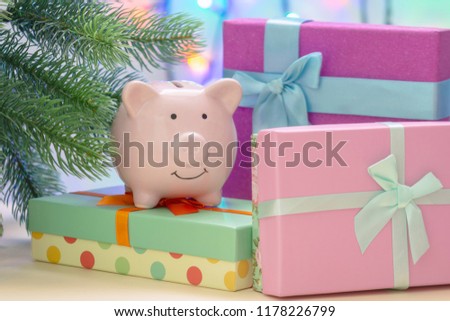 Under the Christmas tree are boxes with gifts. On the box is a small pig piggy bank. Beautiful festive card.