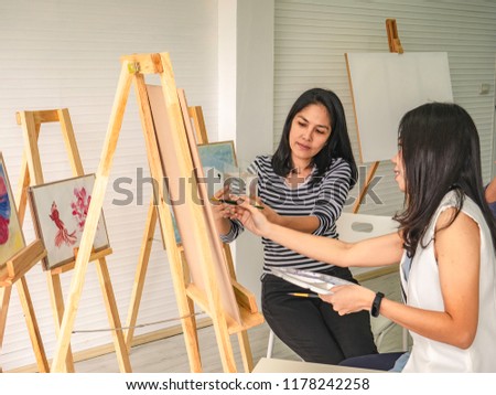 Two young asian woman artist dawning while useing ideas to think and create the best artwork together,fish concept