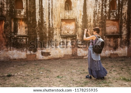 The girl is taking photos in Fort Amer. India. The fortified residence of Raja Man Singha.In northern suburb of Jaipur, on the crest of a rocky hill behind Lake Maota.
