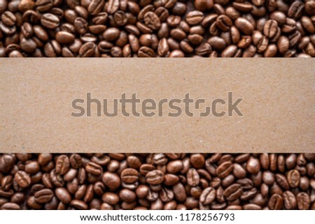 Roasted coffee beans background with blank brown paper for producst label 