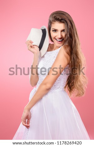 A beautiful and cute young lady posing over pink background. Fashion concept.