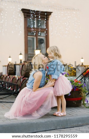 mom and daughter look at each other and kiss