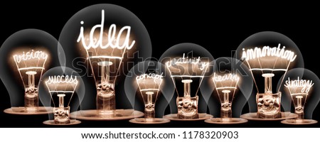 Photo of light bulbs with shining fibers in shapes of IDEA and INNOVATION concept related words isolated on black background Royalty-Free Stock Photo #1178320903