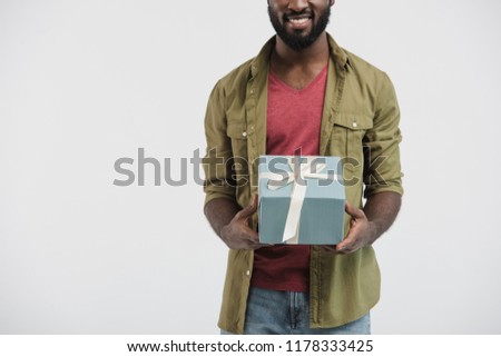 cropped image of smiling african american man holding present box isolated on white 