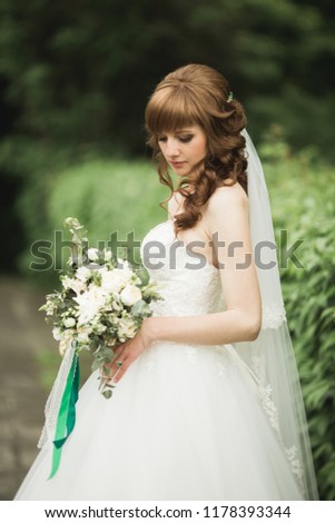 Portrait of stunning bride with long hair posing with great bouquet