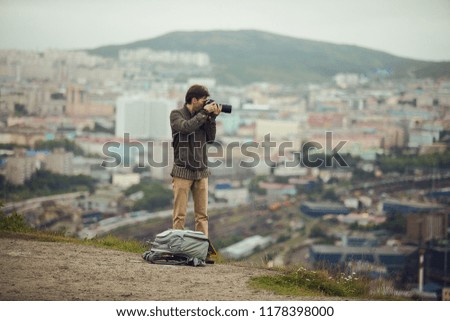Man is taking photo against the city top view