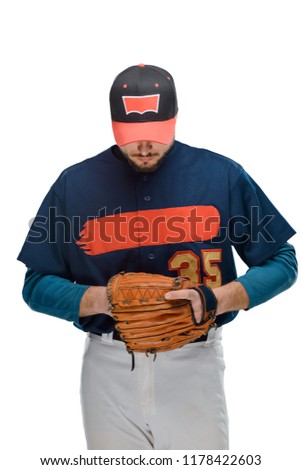 Baseball player looking down, getting ready for a match. Man dressed in a pitcher uniform, isolated on white.