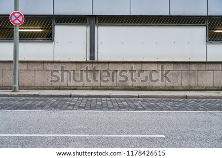 Empty street and sidewalk in front of a wall in the city of Hamburg Royalty-Free Stock Photo #1178426515