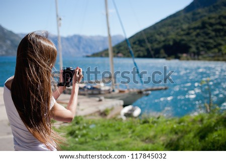 Woman takin a photo of yacht