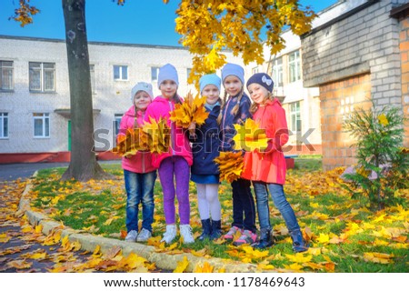girlfriends with large bouquets of autumn foliage, hugging standing under the autumn foliage