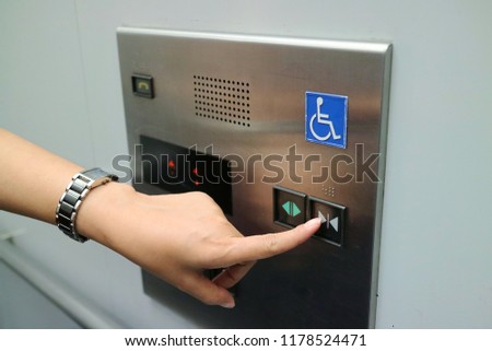Asian woman pressing the disabled elevator button of the elevator. Soft focus. Technology and sign concept.