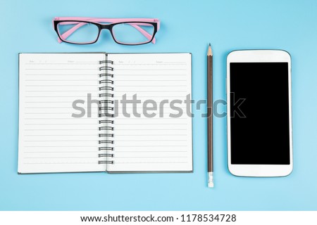 Notebook mobile phone on blye pink glasses background pastel style with copyspace flatlay