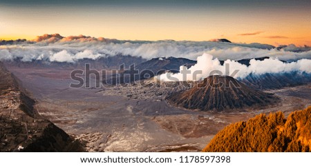 Mount Bromo panorama high resolution photo in early morning with volcanic smoke motion blur from crater and Semeru volcano peak background