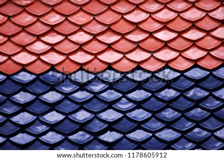 Abstract scene of Red and Blue earthenware tiles or calls tiles consists of fish scales on the roof of temple bangkok thailand - Red and blue separate different concept