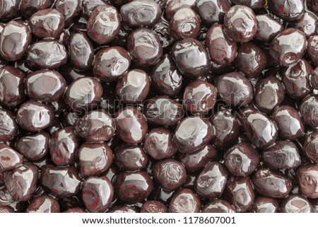 Tasty brine cured Grade A Mediterranean black olives in a close up full frame view for a healthy appetizer or snack or used as an ingredient in cooking