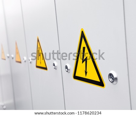 A row of lockers with warning sign high voltage.