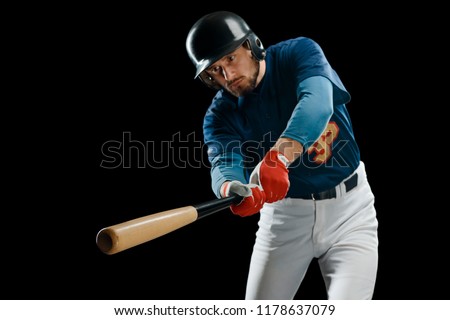 Wooden bat in hitter's hands, selective focus. Male baseball player on black background with free place for text.