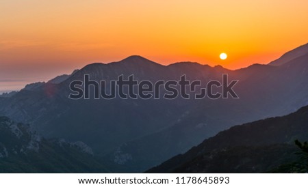Amazing sunset above great mountains "Paklenica" in Croatia. The orange sun near the horizon. Illuminating mountains and rocks by sun. Beautiful view on sunset landscape. Royalty-Free Stock Photo #1178645893